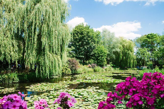 From Paris: Monet Gardens & Giverny Bike Tour with Picnic Stop - Giverny approach: church, cemetery, and Hotel Baudy sightings